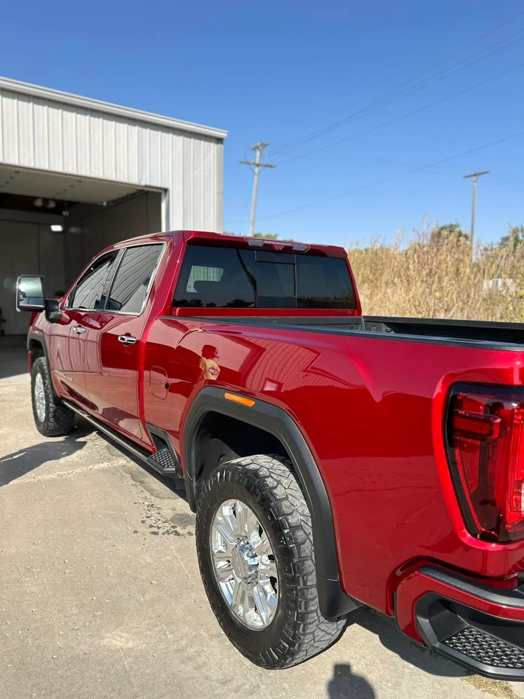 Red GMC Denali HD pickup truck, rear three-quarter view