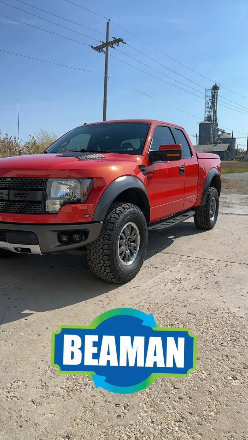 Red Ford Raptor pickup truck, front three-quarter view
