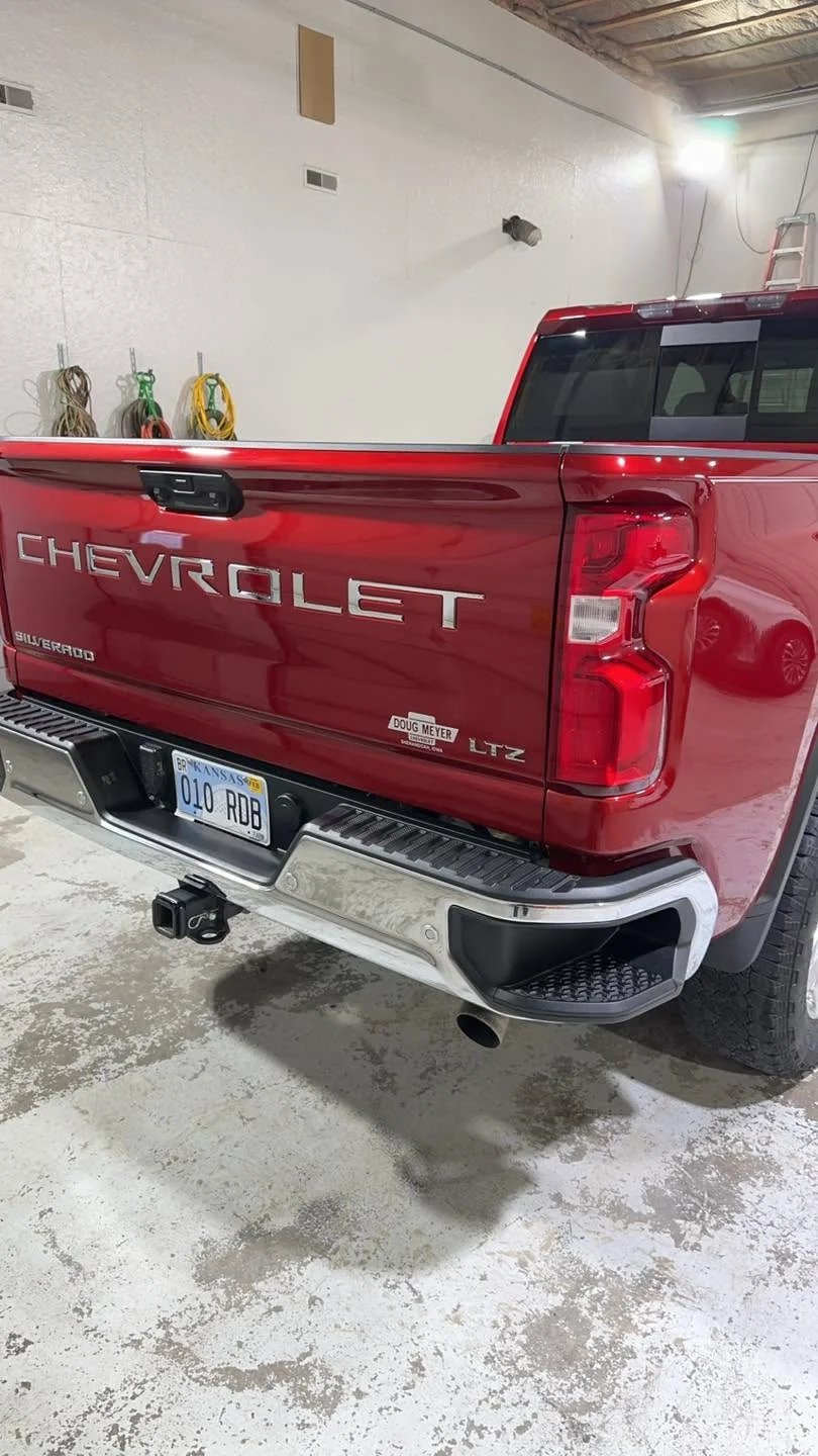 Red Chevrolet Silverado LTZ pickup, rear tailgate view in garage