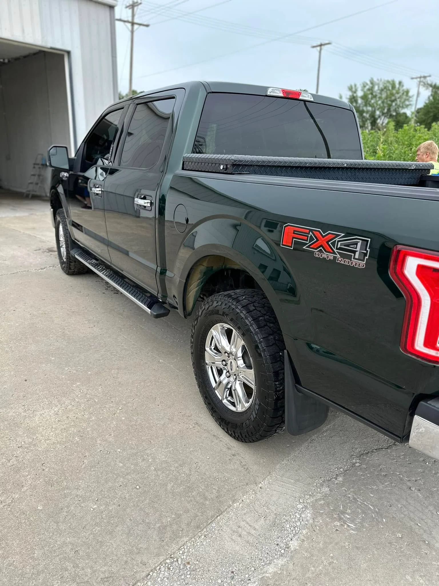 Green Ford F-150 XLT FX4 pickup, driver-side rear view