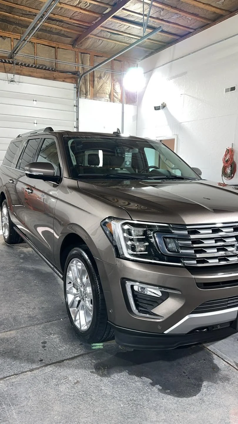 Brown Ford Expedition SUV, front three-quarter view in garage