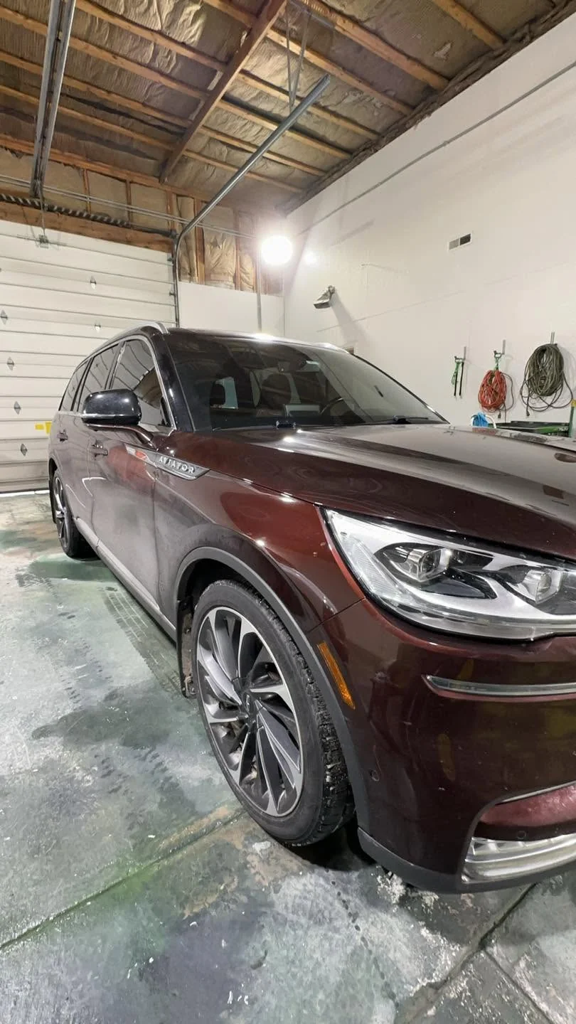 Dark red Lincoln Aviator SUV, front three-quarter view in garage