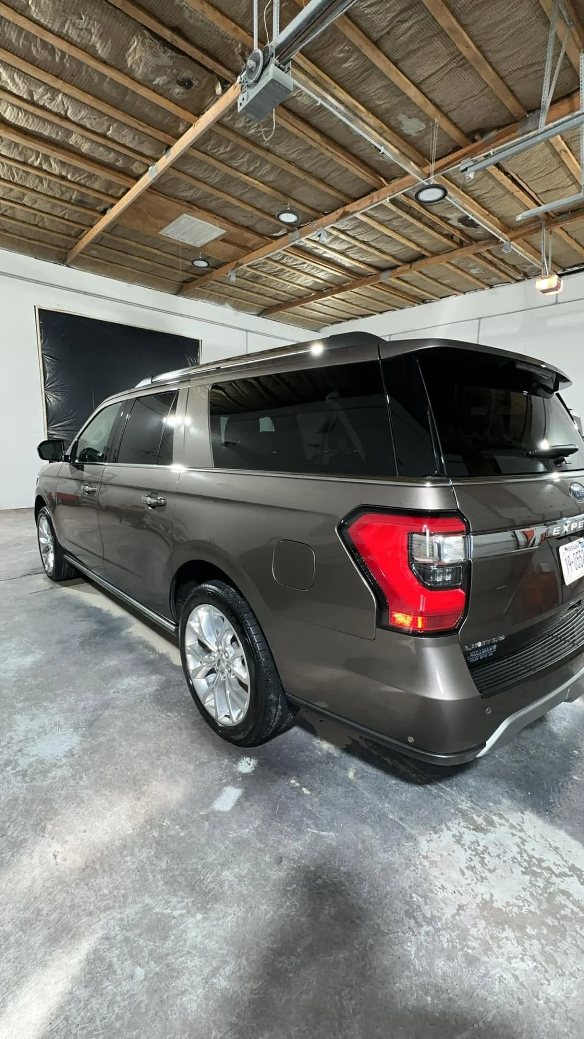 Brown Ford Expedition SUV, rear three-quarter view in garage