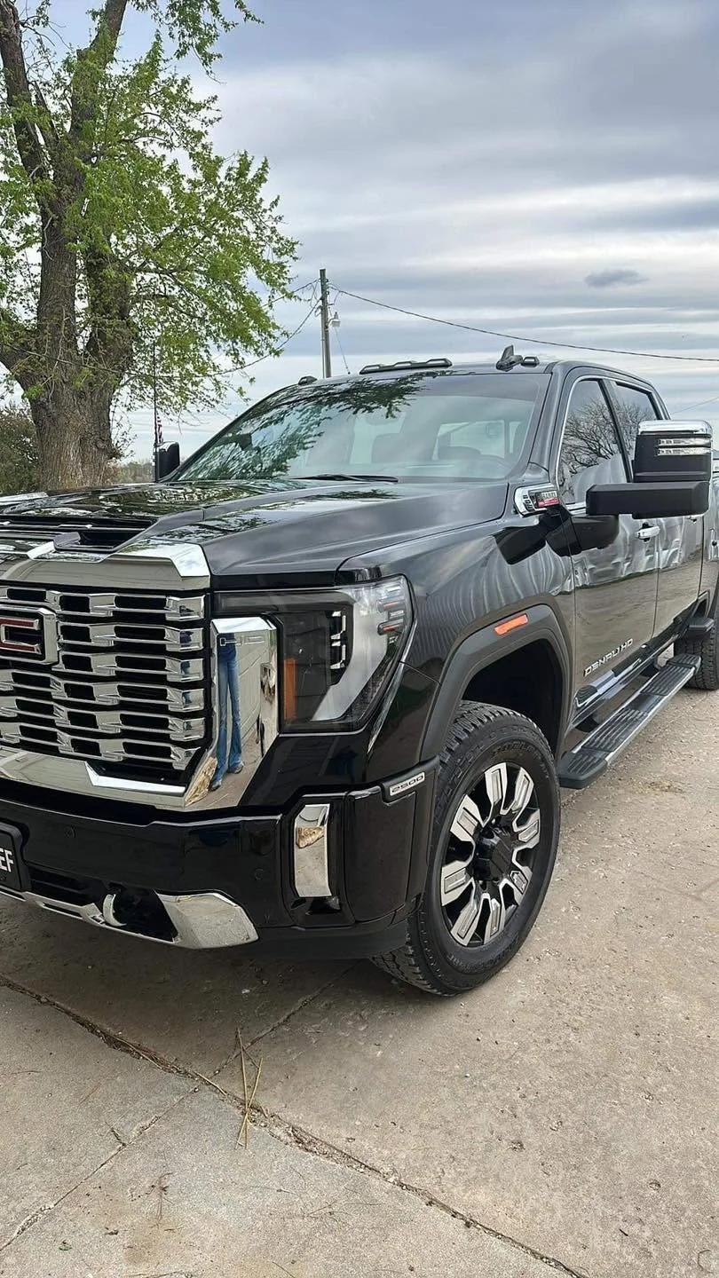 Black GMC Sierra Denali HD pickup, front three-quarter view