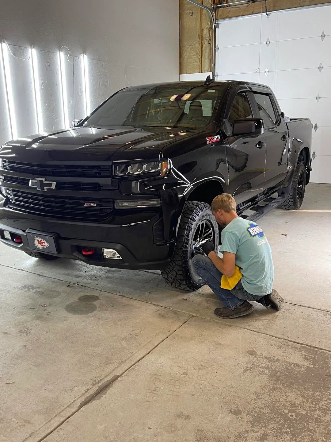 Black Chevrolet Silverado Z71 pickup being detailed in shop