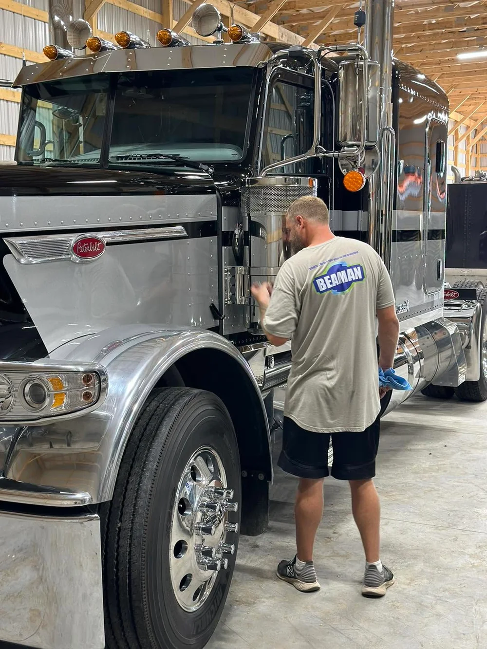 Beaman detailing a chrome and black Peterbilt semi truck